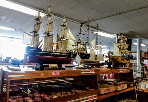 Display of intricately crafted model ships in a store, showcasing various sizes and designs.