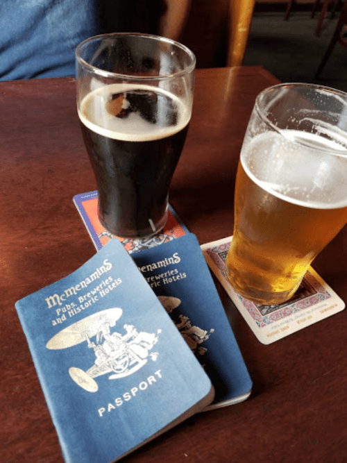 Two pints of beer on a table, with two blue passports labeled "Memorabilia" beside them.