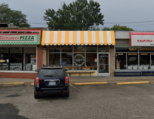 A storefront with a yellow and white striped awning, labeled "Homemade Vicky's," next to a pizza shop.