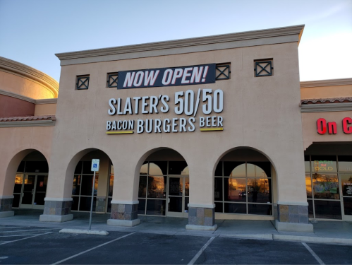 Sign for Slater's 50/50, a restaurant featuring burgers and beer, with "NOW OPEN!" displayed prominently.