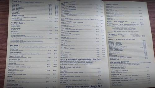 Menu featuring various food items including subs, salads, pizza, calzones, and Vietnamese sandwiches with prices listed.