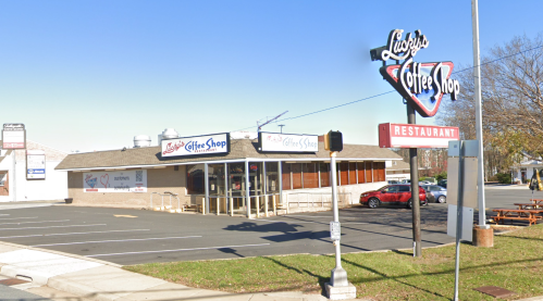 Exterior view of Luigy's Coffee Shop, featuring a sign and a parking lot on a clear day.
