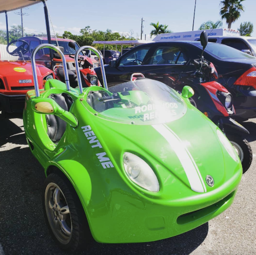 A bright green rental car with a sporty design, featuring a transparent windshield and two seats.