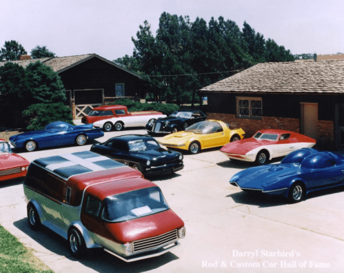 A collection of classic cars displayed outdoors at Darryl Starbird's Rod & Custom Car Hall of Fame.