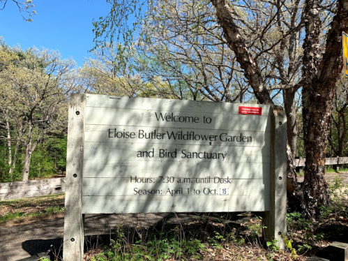 Sign welcoming visitors to Eloise Butler Wildflower Garden and Bird Sanctuary, with hours and seasonal information.