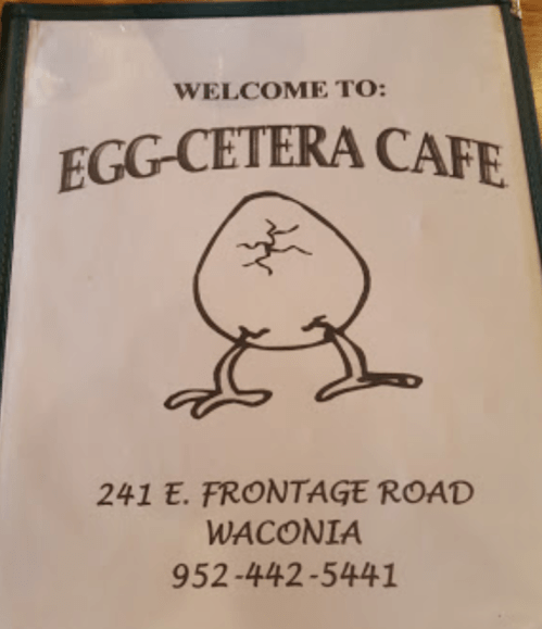 Menu cover for Egg-Cetera Cafe, featuring a cracked egg illustration and contact details.