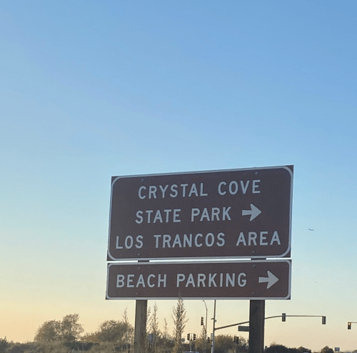 Sign for Crystal Cove State Park, Los Trancos Area, with an arrow pointing to beach parking.