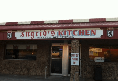 Sign for "Ingrid's Kitchen" Bakery & Delicatessen, featuring a stone facade and red awning. Carry-out parking only.
