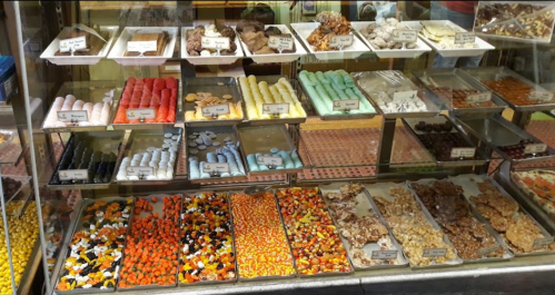 A colorful display of various candies and sweets in a glass case, featuring different shapes and textures.