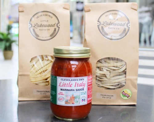 A jar of marinara sauce with two bags of pasta in the background, all from Little Lakewood Pasta Co.