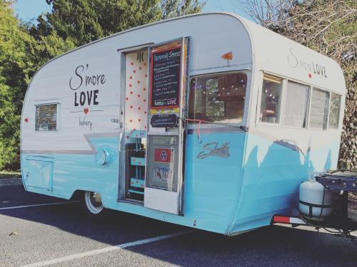 A vintage blue and white food truck named "S'more Love" with a menu board and heart decorations.