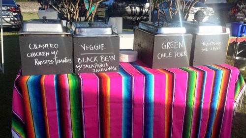 A colorful table with three food containers labeled: Cilantro Chicken, Veggie Black Bean, and Green Chile Pork.