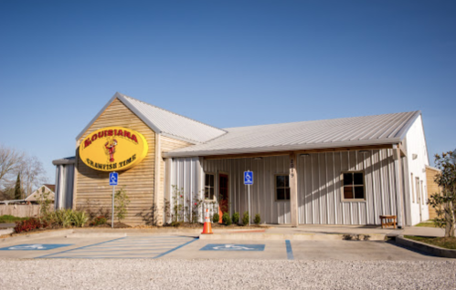Exterior of a building labeled "Louisiana Crawfish Time," featuring a metal roof and accessible parking spaces.