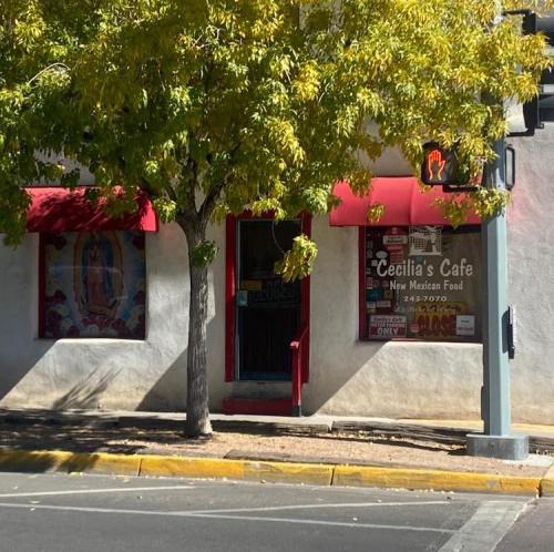 A small café with a red awning and a tree outside, featuring a sign for New Mexican food.