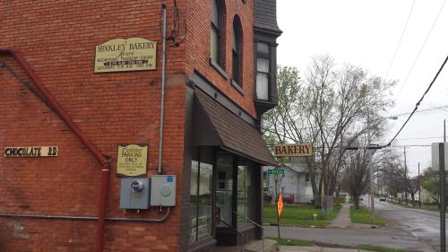 A brick building with signs for "Hinckley Bakery" and "Chocolate LD," located at a street corner on a cloudy day.