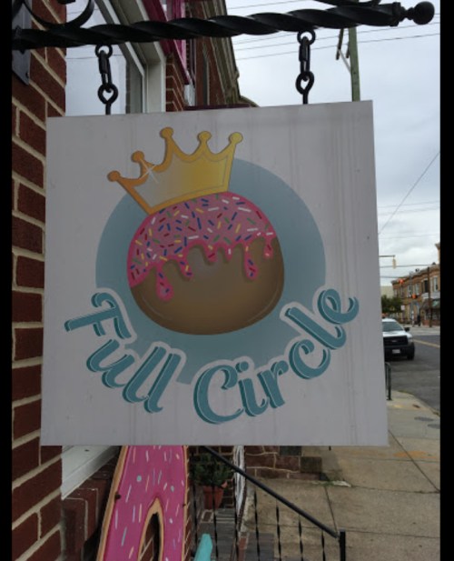 Sign for "Full Circle" featuring a donut with pink icing and sprinkles, topped with a crown.