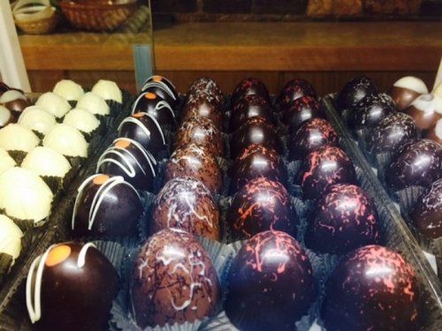 A display of assorted chocolate truffles, featuring dark and white chocolate with decorative toppings.