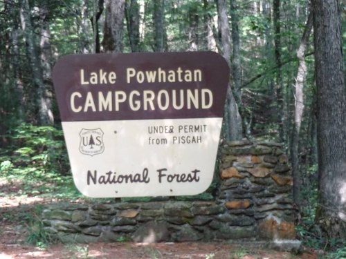 Sign for Lake Powhatan Campground in Pisgah National Forest, featuring a stone base and surrounded by trees.