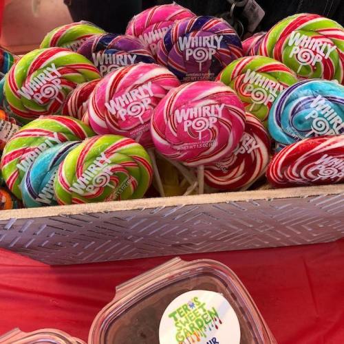 A colorful display of Whirly Pop lollipops in various flavors arranged in a basket on a red tablecloth.