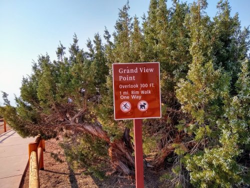 Sign for Grand View Point with details on overlook height, distance for rim walk, and icons for biking and walking.