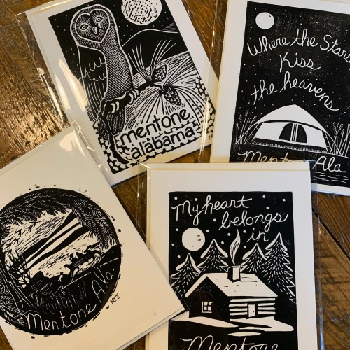 Four illustrated cards featuring black and white designs of nature, an owl, a tent, and a cabin, all themed around Mentone, Alabama.