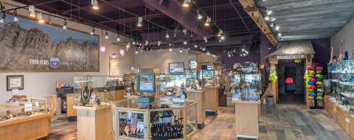 Interior of a jewelry store featuring display cases, mountain-themed decor, and colorful hats for sale.