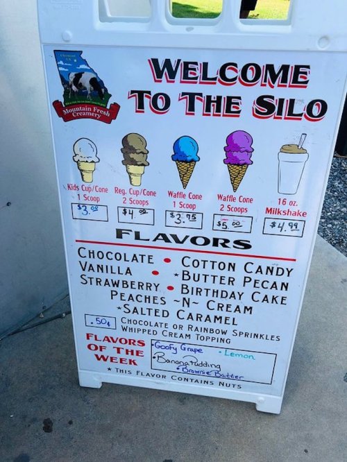 Signboard displaying ice cream flavors and prices, including options like chocolate, vanilla, and birthday cake.