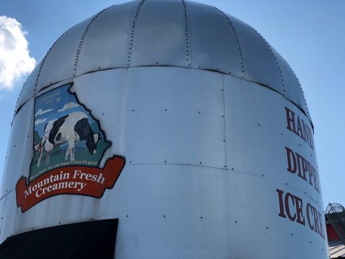 A silver silo with a sign for Mountain Fresh Creamery, advertising handmade dipped ice cream.