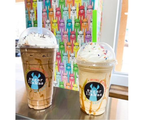Two colorful milkshake cups topped with whipped cream and sprinkles, set against a vibrant bunny-patterned background.