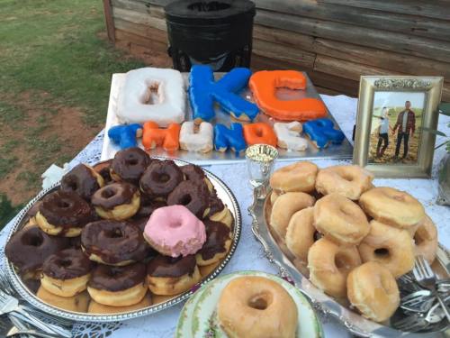 A table with various donuts, including chocolate, glazed, and a pink one, alongside a colorful "OKC THUNDER" display.