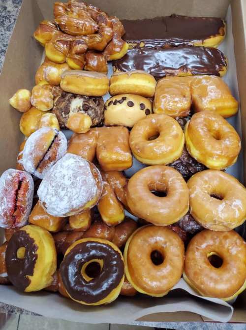 A box filled with a variety of donuts, including glazed, chocolate-covered, and filled options.
