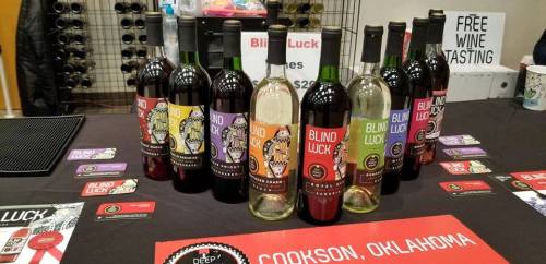 A display of various bottles of "Blind Luck" wine, with a sign for free wine tasting in Cookson, Oklahoma.