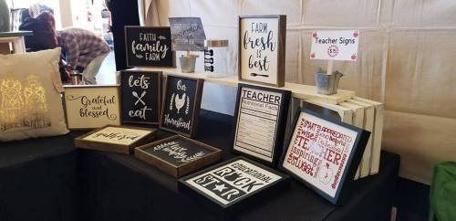 A display of decorative signs and wooden plaques with various inspirational and educational messages.
