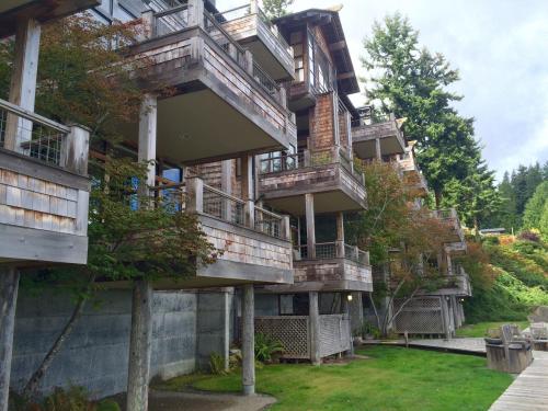 A row of wooden balconies on a multi-story building surrounded by trees and greenery.