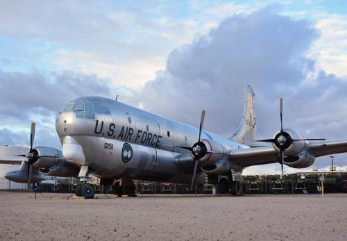 A vintage U.S. Air Force aircraft parked on a desert tarmac under a cloudy sky.