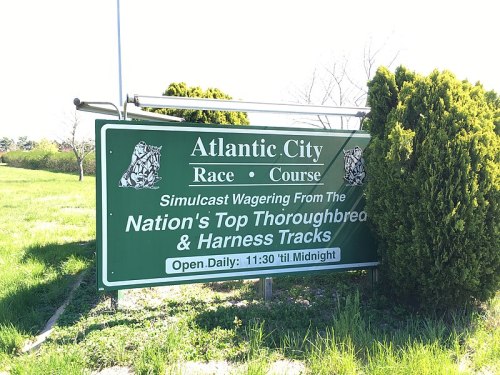 Sign for Atlantic City Race Course promoting simulcast wagering on thoroughbred and harness tracks, open daily until midnight.