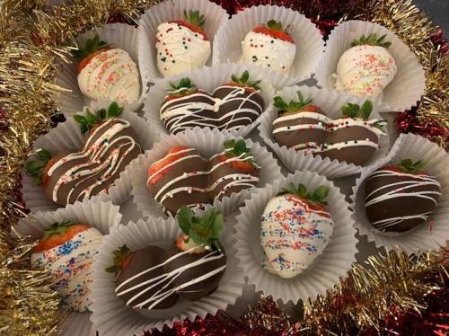 A festive arrangement of chocolate-covered strawberries in white and dark chocolate, decorated with sprinkles.