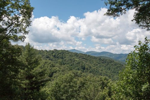 A scenic view of lush green mountains under a partly cloudy sky.