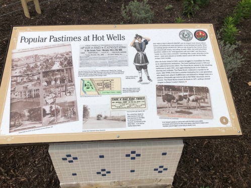 Sign displaying historical information about popular pastimes at Hot Wells, featuring images and text.