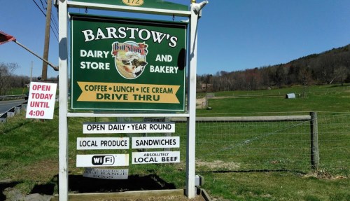 Sign for Barstow's Dairy Store and Bakery, offering coffee, lunch, ice cream, local produce, and sandwiches. Drive-thru available.