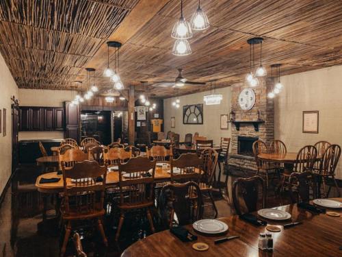 Cozy dining room with wooden tables and chairs, warm lighting, and a stone fireplace, creating a rustic atmosphere.