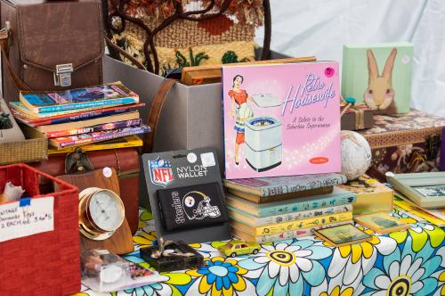 A colorful table display featuring vintage books, a retro washing machine illustration, and various collectibles.