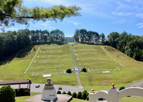 A hillside with large white text displaying the Ten Commandments and other biblical references against a blue sky.