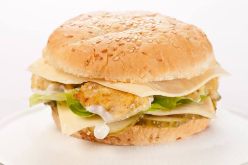 A sesame seed bun sandwich with crispy chicken, lettuce, cheese, pickles, and creamy sauce.