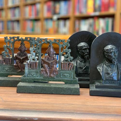 Bronze bookends featuring literary figures, with intricate designs and a library background.