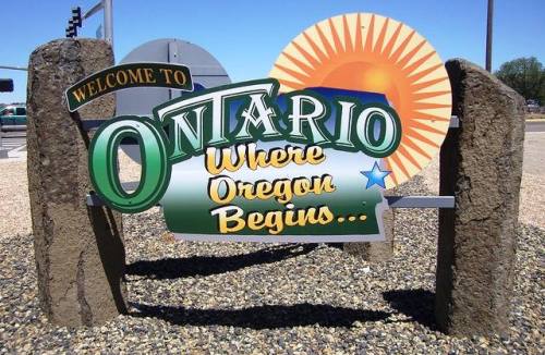 Welcome sign for Ontario, Oregon, featuring a sun graphic and the text "Where Oregon Begins."