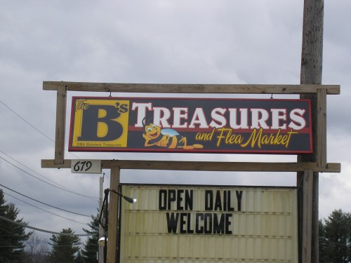 Sign for "B's Treasures and Flea Market" with a cartoon bee, stating "Open Daily" and "Welcome."