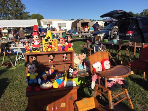 A vibrant flea market scene with various vintage toys, including Mickey and Minnie Mouse, and colorful dolls on display.