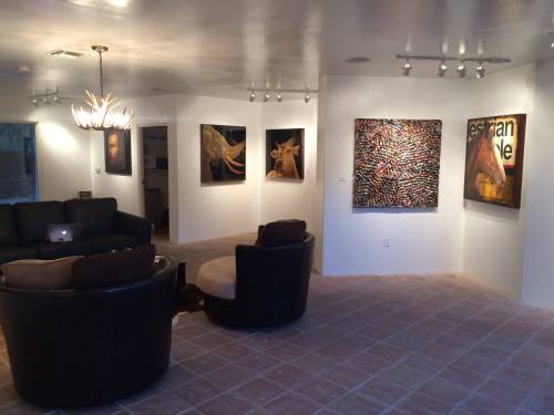 A modern living space featuring two circular sofas, colorful artwork on the walls, and warm lighting.