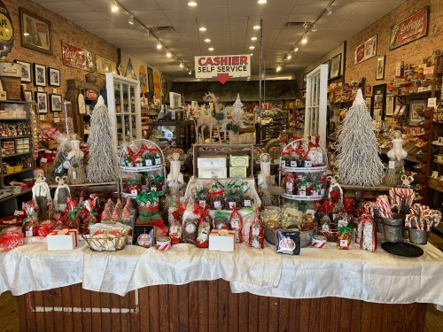 A festive display of holiday treats and decorations in a charming store, featuring gift baskets and seasonal decor.